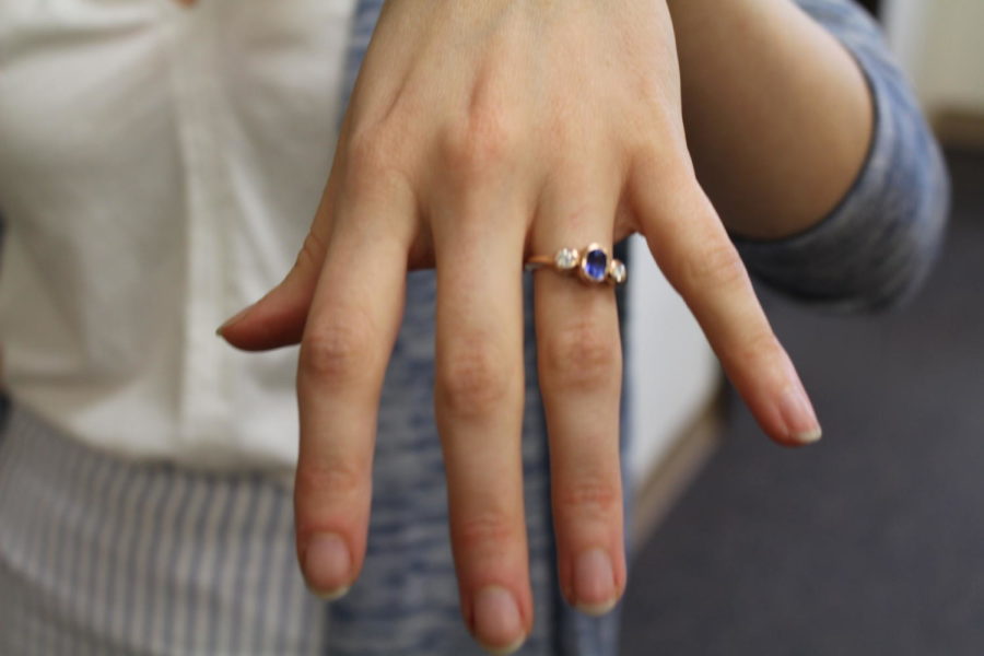 Everitts fiancé designed this ring. He chose the colors specifically to go with her outfits. The diamonds represent Everitt and her fiancé, and the sapphire, her birthstone, represents their union.
